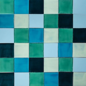 May include: A tiled wall with a checkerboard pattern in shades of blue, green, and white.