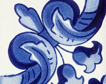 May include: A blue and white ceramic tile with a floral design. The tile features a stylized floral motif with a blue and white color scheme. The design is intricate and detailed, with a focus on the swirling lines and curves of the flowers.