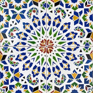 May include: A square tile featuring a geometric pattern in shades of blue, green, red, yellow, and white. The pattern is symmetrical and features a central starburst design.
