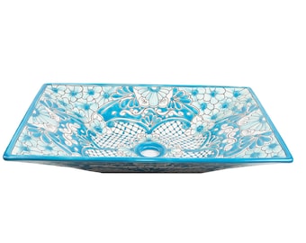 May include: A rectangular ceramic sink with a blue glaze and white floral pattern. The sink has a single drain hole in the center.