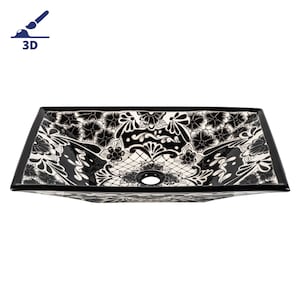 Peut inclure: Un lavabo rectangulaire en céramique avec un motif floral noir et blanc. Le lavabo a un seul trou de vidange au centre.