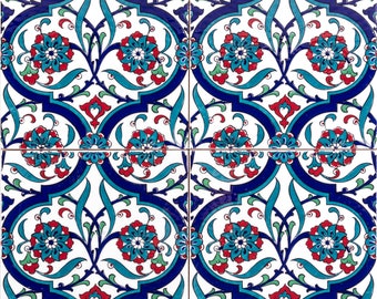 Op de afbeelding: Een herhalend patroon van blauwe, rode en groene bloemmotieven op een witte achtergrond. Het ontwerp doet denken aan traditionele Turkse tegels.