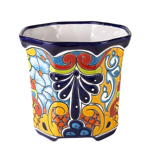 Może przedstawiać: Kolorowa, ośmiokątna doniczka ceramiczna z niebieską krawędzią i misternymi wzorami kwiatowymi w odcieniach żółtego, czerwonego, niebieskiego i zielonego.