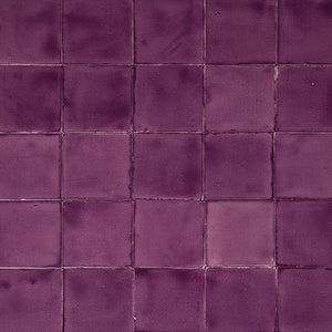 Könnte beinhalten: Eine Wand, die mit quadratischen, violetten Fliesen gefliest ist. Die Fliesen sind in einem Gittermuster angeordnet.