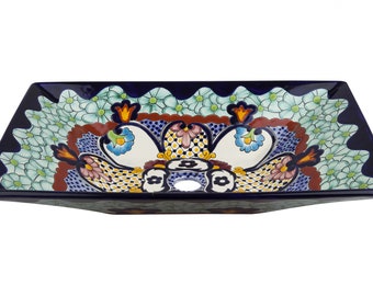 May include: Rectangular ceramic sink with a dark blue rim and a floral design. The sink features a central motif with white, blue, yellow, and pink flowers. The edges are decorated with a repeating pattern of small, light blue flowers.