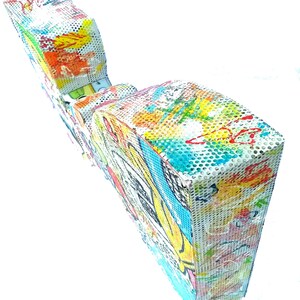 May include: A colorful, abstract sculpture made of metal mesh. The sculpture is painted with bright colors and has a unique, organic shape.