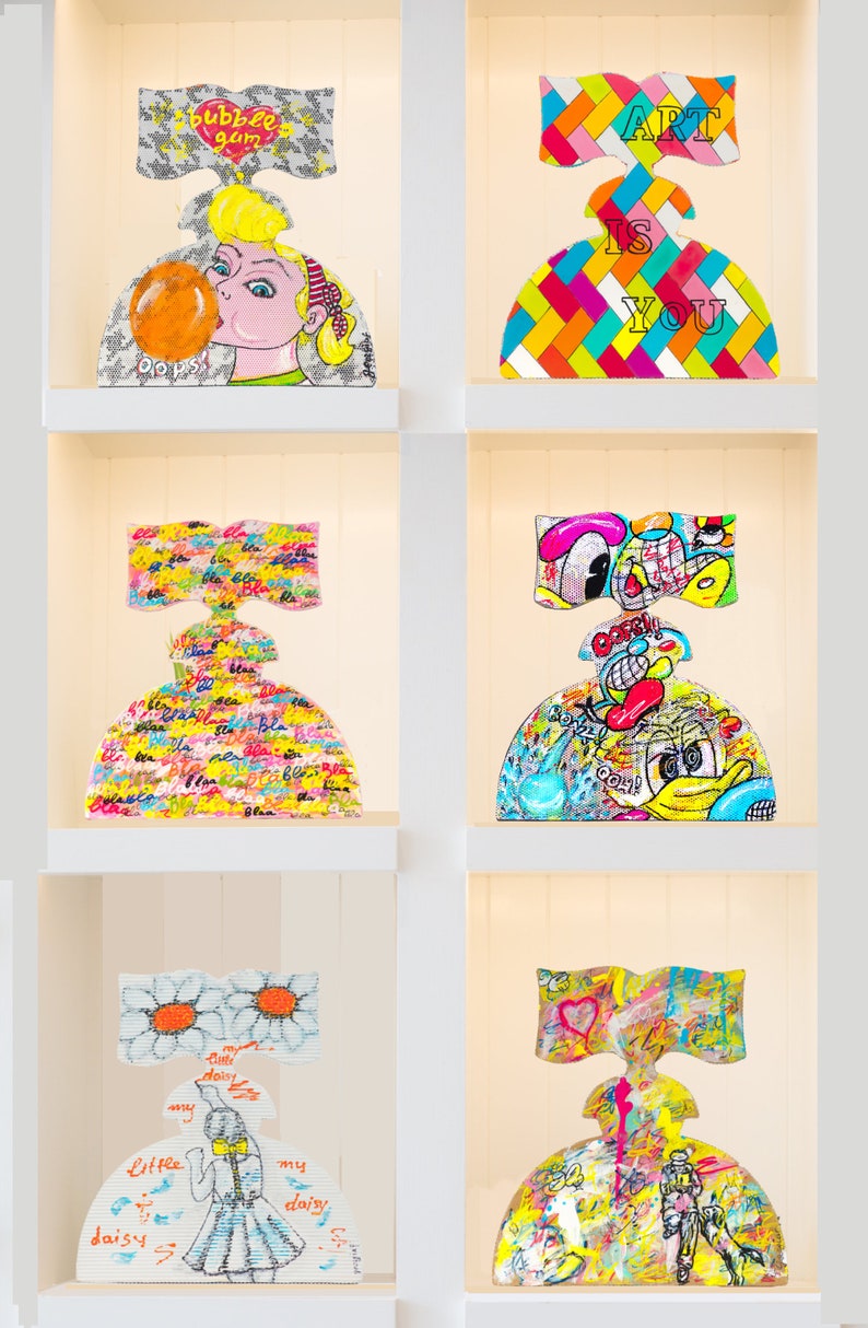 May include: Six colorful ceramic sculptures of women with different designs and patterns. The sculptures are displayed on white shelves in a white room. The sculptures are all in the shape of a woman with a large skirt and a bow on her head. The designs on the sculptures include a bubble gum, a checkered pattern, a pattern of the word "bla", a cartoon character, a daisy, and a heart.