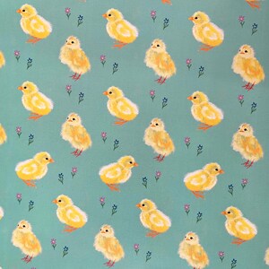 Peut inclure: Motif r&eacute;p&eacute;t&eacute; de poussins jaunes avec des becs et des pattes orange sur fond turquoise. De petites fleurs roses et bleues sont dispers&eacute;es dans le motif. Les poussins sont orient&eacute;s dans diff&eacute;rentes directions.