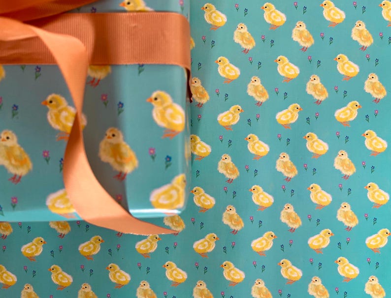 Peut inclure: Papier cadeau avec un motif r&eacute;p&eacute;t&eacute; de poussins jaunes sur fond turquoise et de petites fleurs violettes. Un ruban p&ecirc;che est nou&eacute; autour du cadeau emball&eacute;, pour une touche d&eacute;corative.