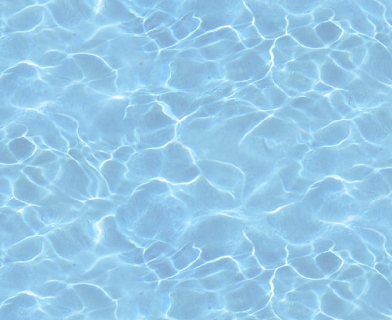 May include: A close-up of a blue pool with rippling water. The water is clear and reflects the sunlight.