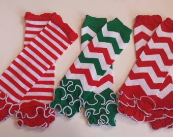 Op de afbeelding: Drie paar rood-witte beenwarmers met een gerimpelde rand. Een paar heeft een gestreept patroon, en de andere twee paar hebben een chevron-patroon.