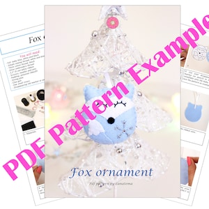 May include: A PDF pattern for a blue felt fox ornament. The pattern includes instructions and a template for creating the ornament. The fox has a white face with black eyes and a snowflake on its chest. The text "Fox ornament" and "PDF pattern by Lanatema" is visible on the page.
