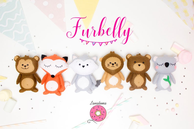 May include: A set of seven felt animal toys, including a monkey, fox, wolf, lion, bear, and koala. The toys are all brown, orange, gray, tan, and gray. The toys are arranged in a row on a white background. The text "Furbelly" is written in pink above the toys.