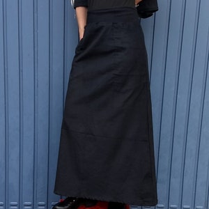 May include: A long black skirt with a simple design and a single pocket on the front.