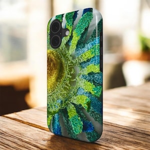Könnte beinhalten: Eine Smartphone-Hülle mit einem hochauflösenden Druck einer strukturierten, lebendigen Blume. Das Design zeigt einen zentralen goldgelben Kern, der von strahlenden Blütenblättern in Limettengrün, Smaragdgrün und Ozeanblau umgeben ist.