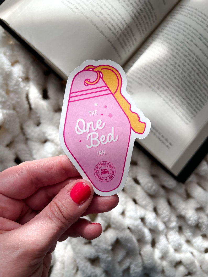Puede incluir: Pegatina rosa en forma de llave con el texto "THE One Bed INN" y un peque&ntilde;o c&iacute;rculo con un icono de cama y el texto "THERE IS ONLY ONE BED YOU HAD ME AT"