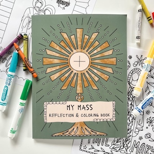 May include: A green "My Mass Reflection & Coloring Book" with a gold-colored sunburst design and a cross. Crayola markers and crayons in various colors surround the book. Coloring pages are visible.