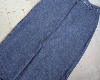 May include: A long, denim skirt in a medium blue wash. The skirt has a classic, straight silhouette and a high waist. The fabric appears to be a medium-weight denim, with subtle fading and wear.