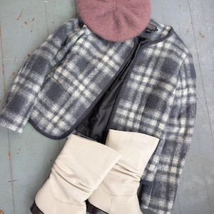 May include: A gray and white plaid jacket with a pink beret and white leather boots.