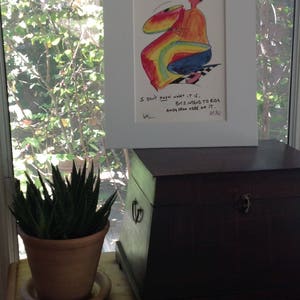 May include: A framed cartoon illustration of a person riding a rainbow-colored object. The caption reads "I don't know what it is, but I intend to ride away from here on it."