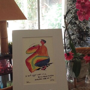 May include: A framed illustration of a person riding a rainbow-colored object. The caption reads "I don't know what it is. But I intend to ride away from here on it."