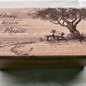 May include: Wooden box with a detailed engraved design. The top features a tree, bench, and the text "Your life was a blessing, your memory a treasure, you are loved beyond words, and missed beyond measure."