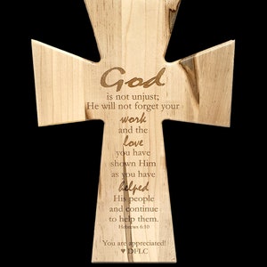 May include: A wooden cross with a laser-engraved message about God's justice and the importance of helping others. The text reads: "God is not unjust; He will not forget your work and the love you have shown Him as you have helped His people and continue to help them. Hebrews 6:10 You are appreciated! DFLC"