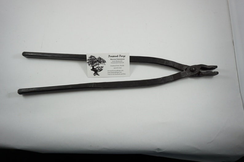 May include: Black metal bonsai pliers with a rounded handle and a small, pointed jaw. The pliers are on a white surface with a business card that reads "Bonsai Forge, Steven Farese, Bonsai, Florida, www.bonsaiforge.com".