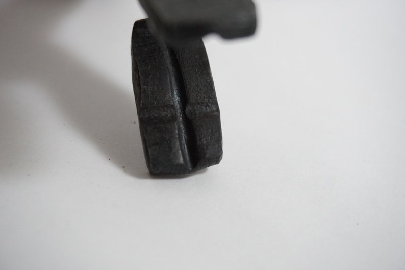 May include: A close-up of a black rubber wheel with a textured surface. The wheel is designed for a toy or model.