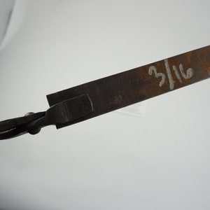 May include: A close-up of a metal tool with a twisted handle and a flat, rectangular blade. The blade is marked with the number "3/16".