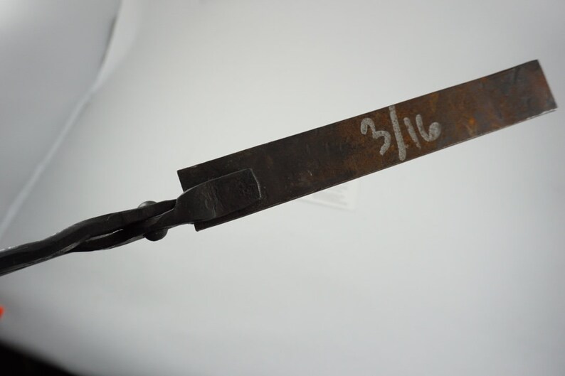 May include: A close-up of a metal tool with a twisted handle and a flat, rectangular blade. The blade is marked with the number "3/16".