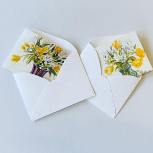 May include: Two white envelopes with floral greeting cards inside. The cards feature watercolor paintings of yellow tulips in a vase.