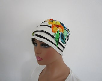 Bonnet chimio, toque, turban, foulard femme en jersey de couleur blanche rayée de noire avec des fleurs multicolore