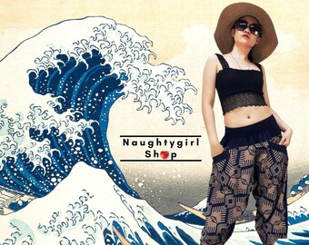 May include: A woman wearing a black tank top, a wide-brimmed straw hat, and black sandals. She is wearing brown and black patterned pants with a blue waistband. The background is a large wave painting.