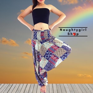 Może przedstawiać: Kobieta w czarnym topie na ramiączkach i kolorowych, wzorzystych spodniach harem. Spodnie mają patchworkowy wzór z motywami paisley i geometrycznymi. Tło to zachód słońca z tęczą.