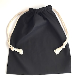 Puede incluir: Una bolsa de cordón negro con un cordón de algodón blanco. La bolsa está hecha de una tela suave y duradera y es perfecta para llevar objetos pequeños.