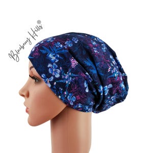 May include: A blue and purple floral print beanie hat. The hat is made of a soft, stretchy fabric and is perfect for keeping your head warm and stylish.