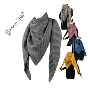 Puede incluir: Cinco bufandas de punto de gofre en diferentes colores. Las bufandas son triangulares y tienen una textura de gofre. Los colores son gris, rosa, azul, amarillo y marrón.