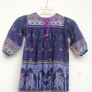 May include: A navy blue tunic top with a floral and elephant print design. The top has three-quarter sleeves, a V-neck with a drawstring, and decorative trim. The brand name "Karni Exports" is visible on the hanger.
