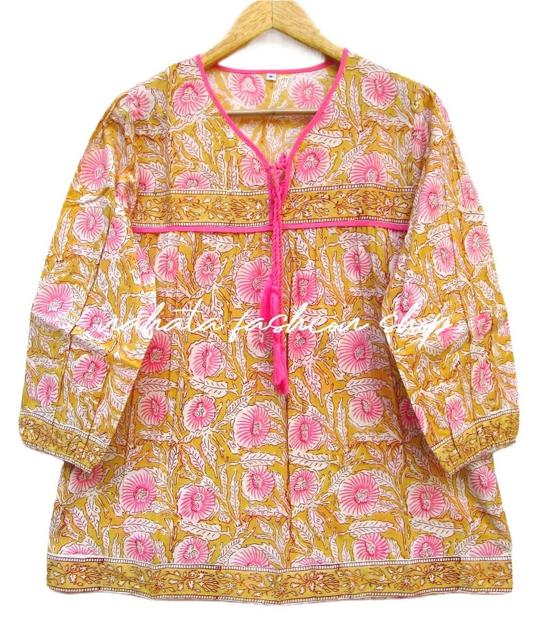 May include: A yellow and pink floral print cotton top with a tie at the neckline and 3/4 sleeves.