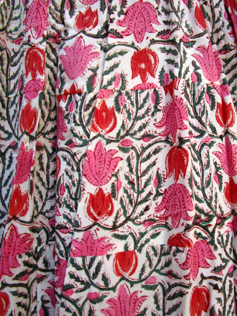 Puede incluir: Tela blanca con estampado floral rosa y verde. Las flores son estilizadas y tienen un dise&ntilde;o tradicional indio.