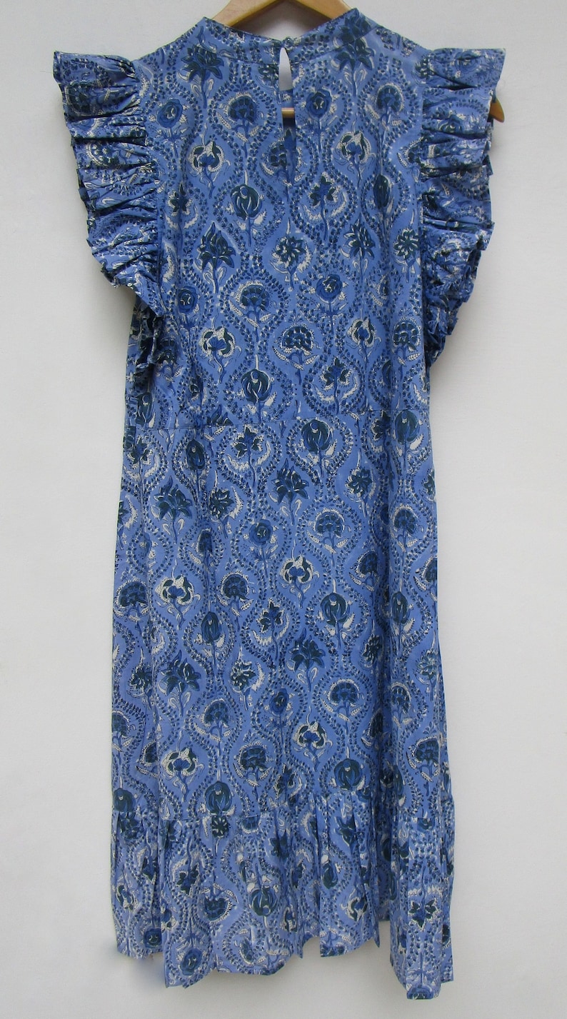 May include: A blue cotton dress with a floral print and ruffled sleeves. The dress has a round neckline and a gathered skirt.
