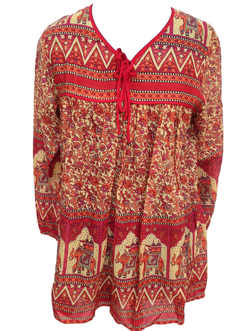May include: A red and cream long-sleeved blouse with an elephant print and a tie at the neckline.
