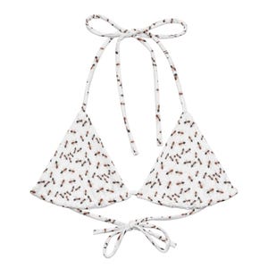 May include: White triangle bikini top with adjustable straps and a tie closure. The top features a pattern of small brown ants.