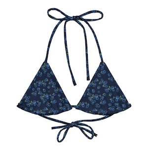 May include: A blue bikini top with a floral print. The top has adjustable straps and ties at the back.