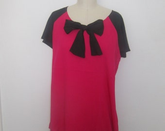 Blusa con bloques de color rosa y negro, lazo y manga dolman. Única en su tipo.