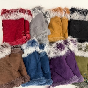 Op de afbeelding: Een verzameling kleurrijke wanten met imitatiebont, in verschillende tinten, waaronder rood, bruin, blauw, paars en zwart. Elke want heeft een zacht, suède-achtig materiaal en een pluizige, contrasterende bontrand rond de manchet.
