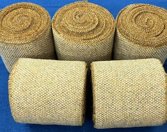 May include: Five rolls of beige and brown textured fabric with a subtle shimmer. The fabric is rolled tightly and has a woven appearance.