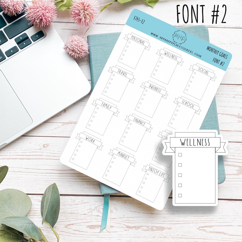 May include: A sheet of printable stickers with a banner design for monthly goals. The stickers are labelled with categories such as personal, wellness, social, travel, business, school, family, finance, work, mindset, and enjoy life. The stickers are designed in a simple black and white style.