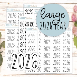 May include: A collection of white stickers with the year "2026" printed in a variety of fonts. A light blue circle with the words "large 2026 YEAR" is also visible. The stickers are designed for planning and organization.